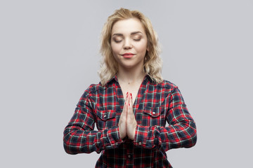 Yoga time. Portrait of calm beautiful blonde young woman in casual red checkered shirt standing...