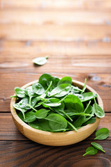Fresh spinach leaves on wooden background. Healthy vegan food