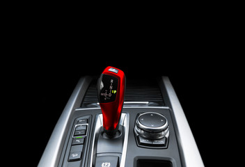 Red Automatic gear stick of a modern car. Modern car interior details. Close up view. Car...