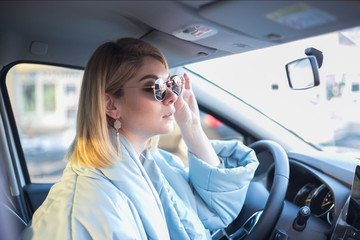 Girl behind the wheel in sunglasses