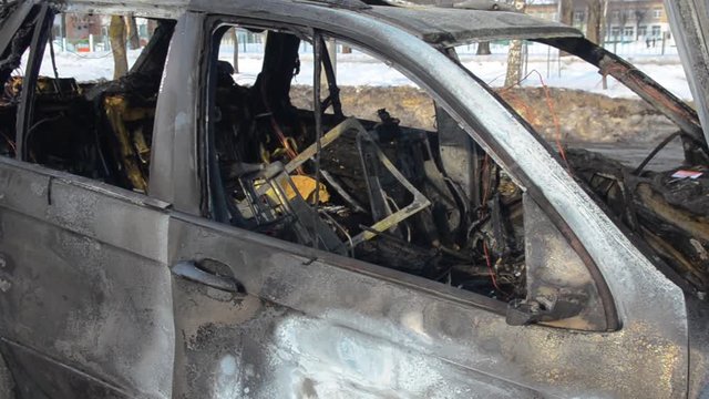 Abandoned and burned car. Burnt car left abandoned on the roadside on a street in the city