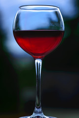 Glass with red wine on a dark background