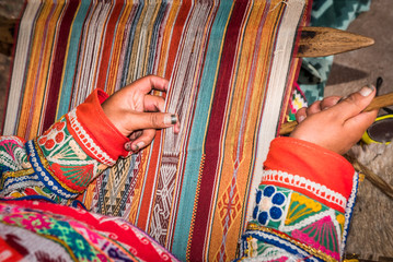 Hands of Peruvian weaver making a blanket