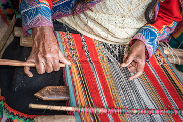 Hands of Peruvian weaver making a striped textile