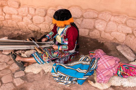Peruvian women sitting on ground weaving