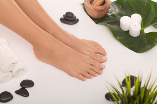 The picture of ideal done manicure and pedicure. Female hands and legs in the spa spot in the white background.