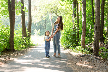 Family, nature and people concept - Mother and daughter spend time together on a walk in the forest