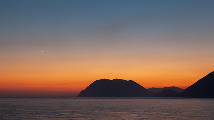 Naklejka na ściany i meble Sunset at sea on Greece seaside in summer with moon