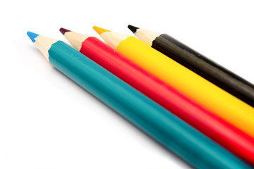 Four colored pencils. The colors cyan, magenta, yellow and black. The concept of polygraphy.