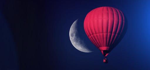 Red balloon in the sky. Aerostat. People in the basket. Fun. Summer entertainment. Romantic adventures. Modern toned photo.