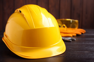 Hard hat and blurred safety equipment on background. Space for text