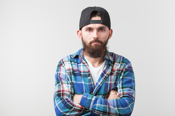 Hipster, lifestyle and people concept - Angry bearded man in a cap posing over the white background