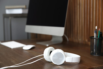 Stylish headphones on office table. Space for text
