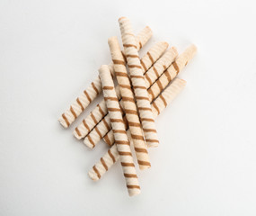 Delicious wafer rolls on white background, top view. Sweet food