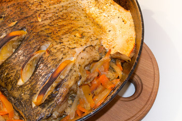 Baked silver carp. Preparing  carp in the oven. Silver carp with side dish at the pan. Fish cook at home.