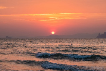 Fototapeta na wymiar Sea sunset landscape with a solar disk above the coastline on the horizon