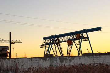 Smolensk / Russia - industrial landscape, portal cranes behind a concrete fence in winter, ecology, environment