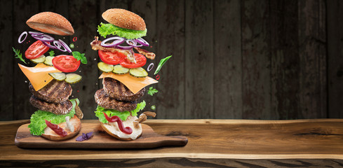 Hamburger ingredients falling down one by one to create a perfect meal. Colorful conceptual picture of burger cooking.