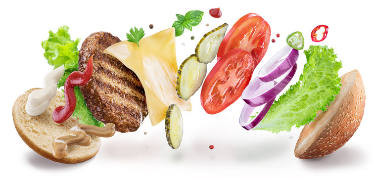 Hamburger ingredients hanging in the air. Colorful conceptual picture of burger cooking. Clipping path.