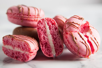 Composition of pink macaroon with reflection on marble and chocolate lines