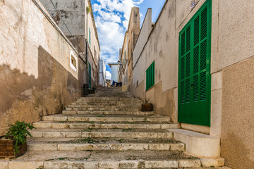 Eine enge mediterrane Treppengasse umschlossen von Mauern führt Aufwärts