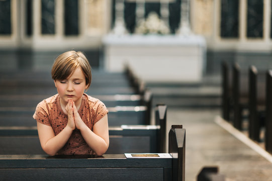 Little boy praying in church