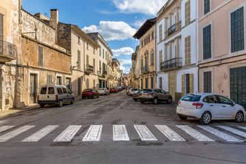 Fototapeta na wymiar Eine typische, mediterrane Gasse mit parkenden Autos auf Mallorca