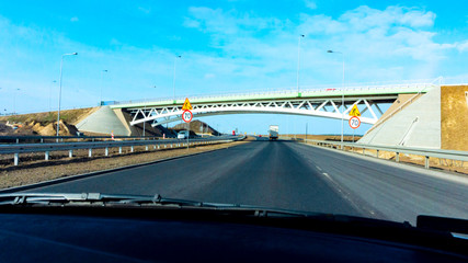 Fototapeta na wymiar Traffic on the highway . Two-lane highway with cars . Modern bridge . 