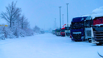 Trucks in a row . Truck on a winter road . will lock movements of trucks during bad weather