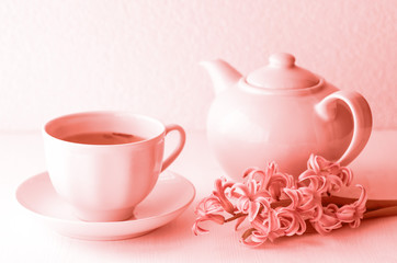 Live coral color is a composition of a teapot and a cup of tea. Fragrant hyacinth