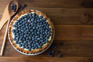 Blueberry Tart or cake with cream and berries. Fresh sweet dessert with fruits. homemade food, wooden, rustic background. Copy space.