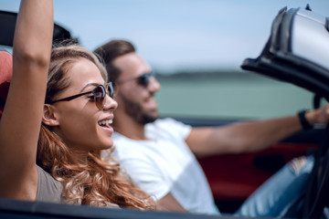 close up.a young woman with her boyfriend in a convertible car