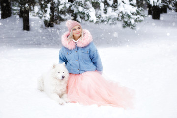 beautiful girl with a dog on a walk in the winter forest. beautiful girl and her pet.