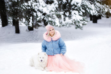 beautiful girl with a dog on a walk in the winter forest. beautiful girl and her pet.