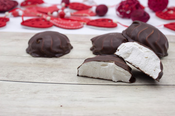 Marshmallows in chocolate on the wooden background