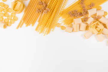An overhead photo of different types of pasta, including spaghetti, penne, fusilli, and others,...