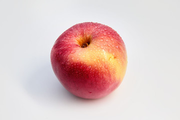 Red Apple in water drops on white background