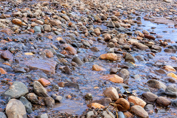 Melt water flows over stony slope in spring
