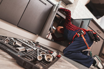 All tools just in case. Seniour handyman repairing washbasin at the kitchen