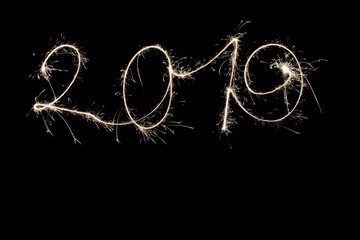 The numbers for the year two thousand and nineteen are written into the night with a sparkler and a...
