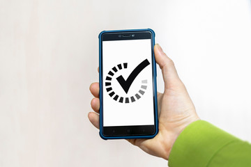 Smartphone with check mark and progression bar in a hand. In progress completed mobile app concept.