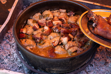Preparing food outdoor for many people, direct on fire in a big pot.