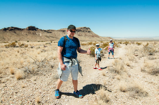 A  Family Standing On The Hiking Trail With A Thumbs Up In A Texas Desert