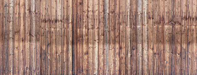 Panorama einer alten, braunen, verwitterten Holzwand mit zwei Doppelreihen Nägeln