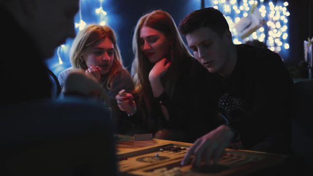 Friends plays backgammon in a blue bar