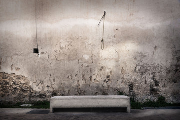 Concrete bench in front of abandoned wall with hangman knot hanging at the wall, Merida, Mexico