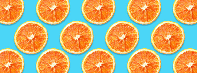 Dry orange slices horizontal pattern design. Cut fruit section isolated on blue background.