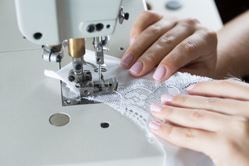 sewing process on sewing professional manufacturing machine with metal needle detailed by white...