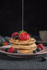 Delicious american pancakes with berries and syrup. Vertical. Closeup