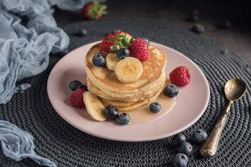 Delicious american pancakes with berries, banana and syrup. Horizontal